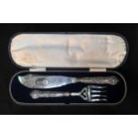 A pair of Victorian silver fish servers with scrolling foliate engraved blades, one side a vacant