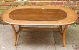 An Ercol elm coffee table, of oval form, raised on downswept supports with stretcher, 115cm long