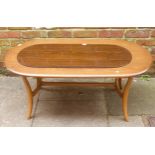 An Ercol elm coffee table, of oval form, raised on downswept supports with stretcher, 115cm long