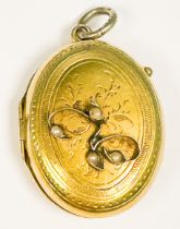 A yellow metal (tests as 9ct or above) oval shaped locket, with diagonal pattern design to the