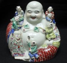 A 20th Century Chinese porcelain figure of a seated laughing Buddha with children, painted in