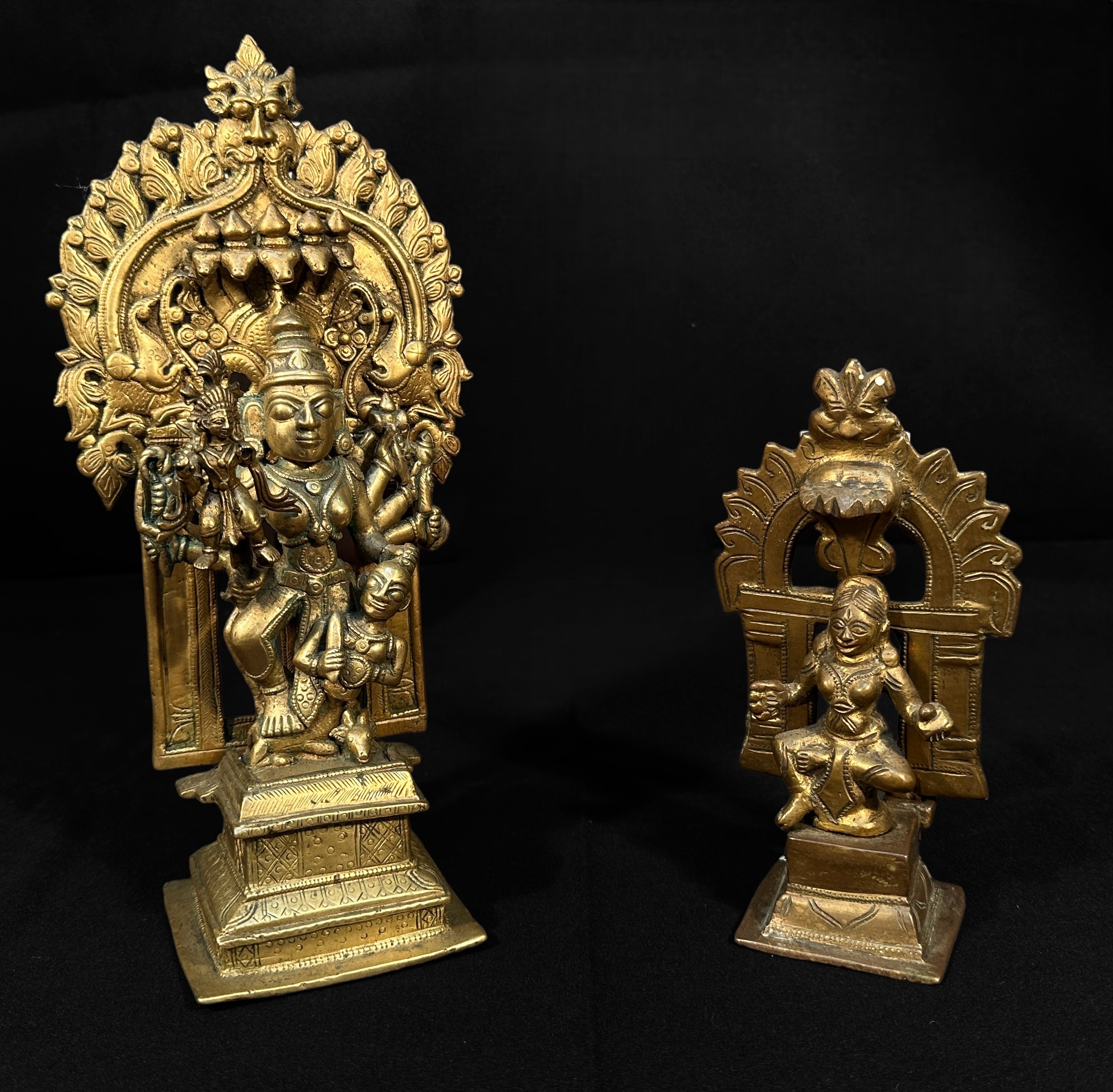 Two copper alloy sculptures of Indian Deities, each with removable back sections, raised on pedestal