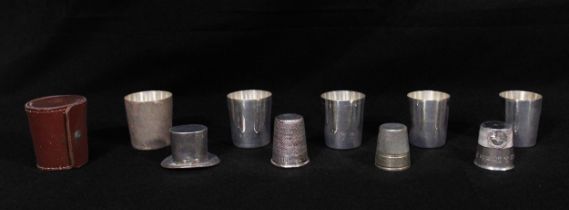 Three novelty 'Just a Thimbleful' spirit cups, together with five graduated silver-plated spirit