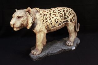A large ivory 'coloured' composite moulded and pierced model of a tiger, modelled standing on