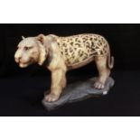 A large ivory 'coloured' composite moulded and pierced model of a tiger, modelled standing on