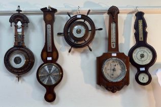 Ten various aneroid barometers, variously mounted on wooden frames including a ships wheels and