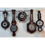 Ten various aneroid barometers, variously mounted on wooden frames including a ships wheels and