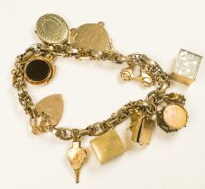 A 9ct yellow gold belcher link charm bracelet with 10 x various charms, including a drum, a scooter,