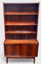 A 1960-70’s rosewood and teak bureau-bookcase with three shelves above a dual-tambor front enclosing