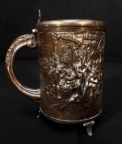 A continental white metal tankard, of cylindrical form and embossed and chased with a pastoral scene