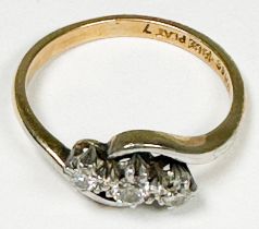 An 18ct yellow gold ring, platinum set with three round diamonds in a twist design, total
