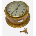 A brass cased ships bulkhead clock, the silvered dial with Roman numerals denoting hours and