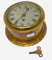 A brass cased ships bulkhead clock, the silvered dial with Roman numerals denoting hours and