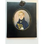 An early 19th century oval portrait miniature of a Junior Naval Officer, in right hand a brass