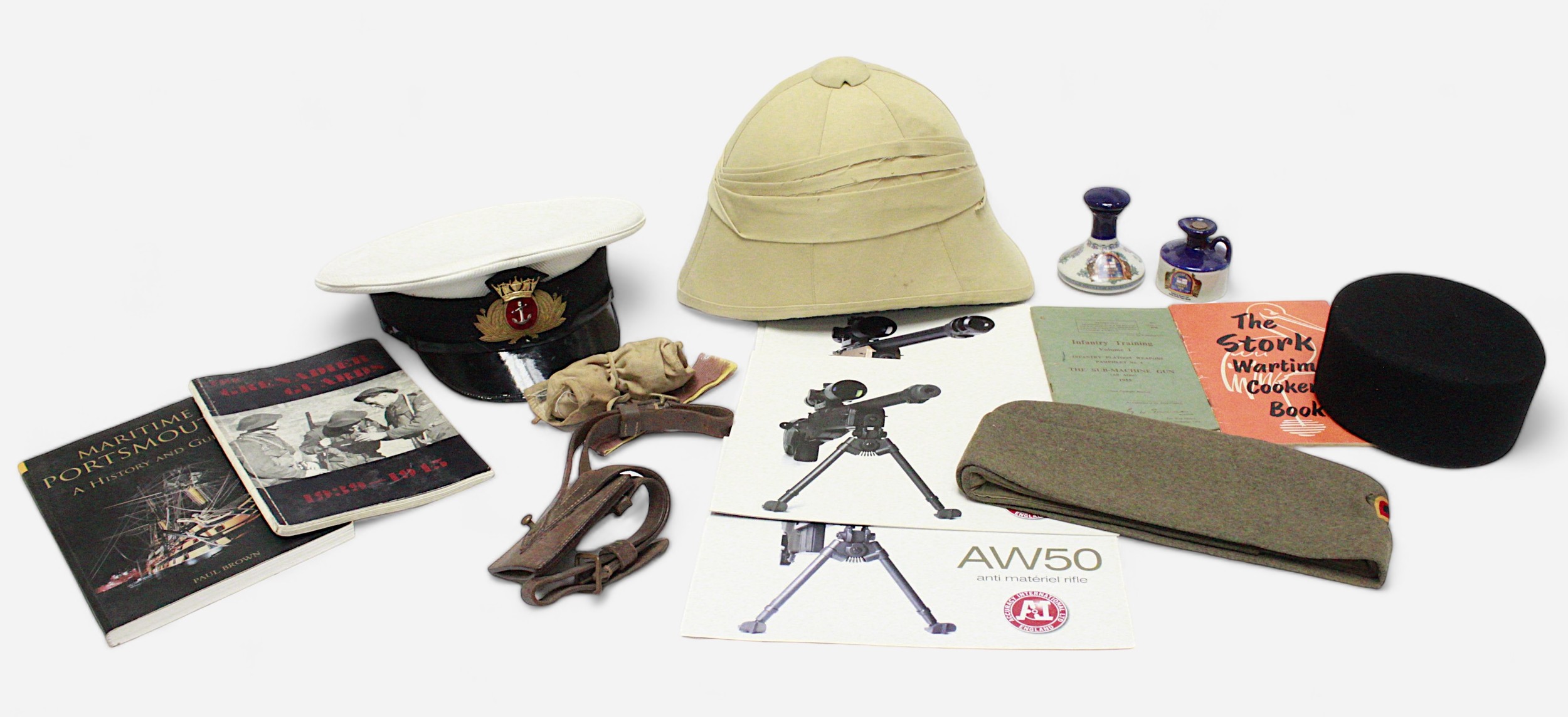 Four various reproduction military caps and helmets, comprising Merchant Navy Officer’s Cap, West