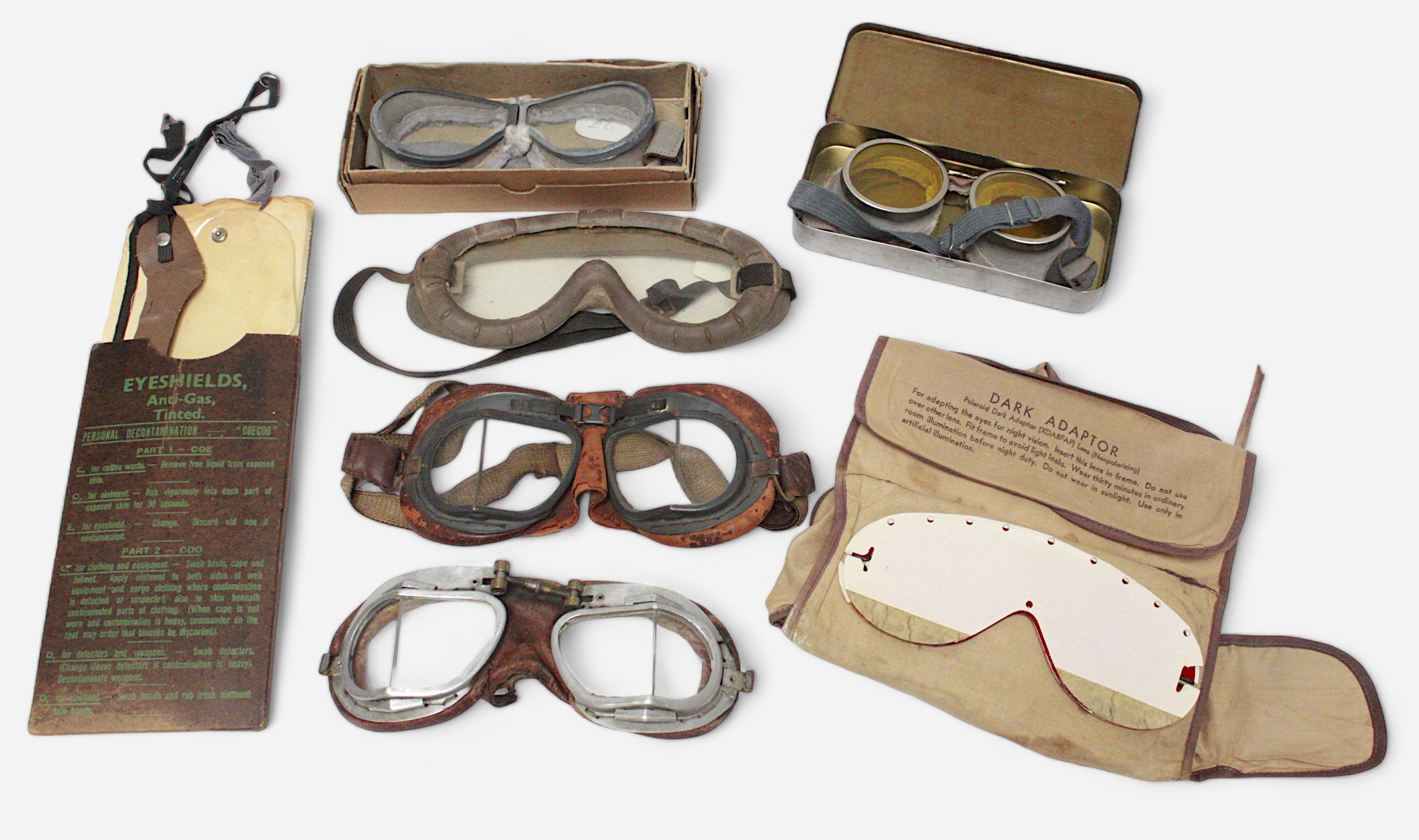 A collection of WWII goggles including RAF MKVIII Flying Goggles, Polaroid All-Purpose Goggle Kit