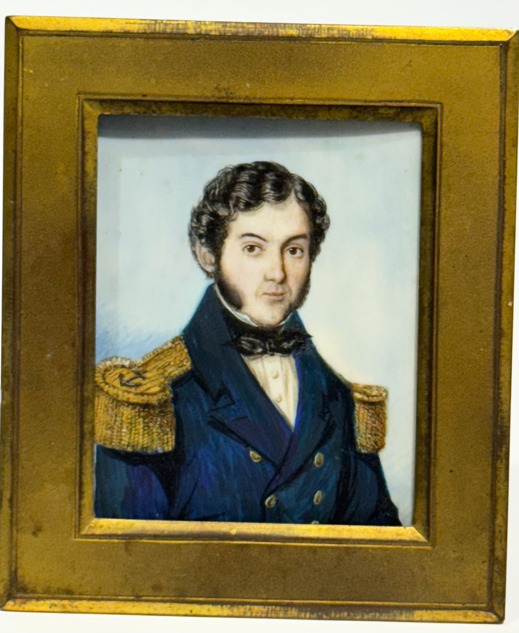 A Mid-19th century rectangular portrait miniature of a Naval Commander, with black curly hair and