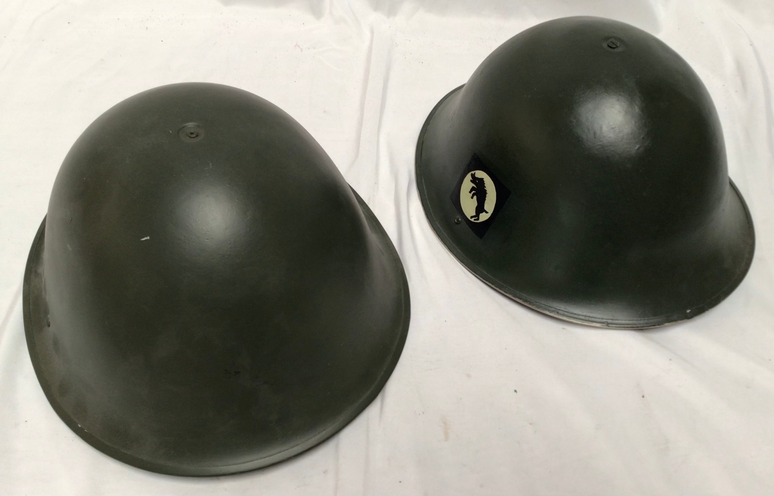 A WWII era British green painted steel turtle back helmet, with painted patches to each side