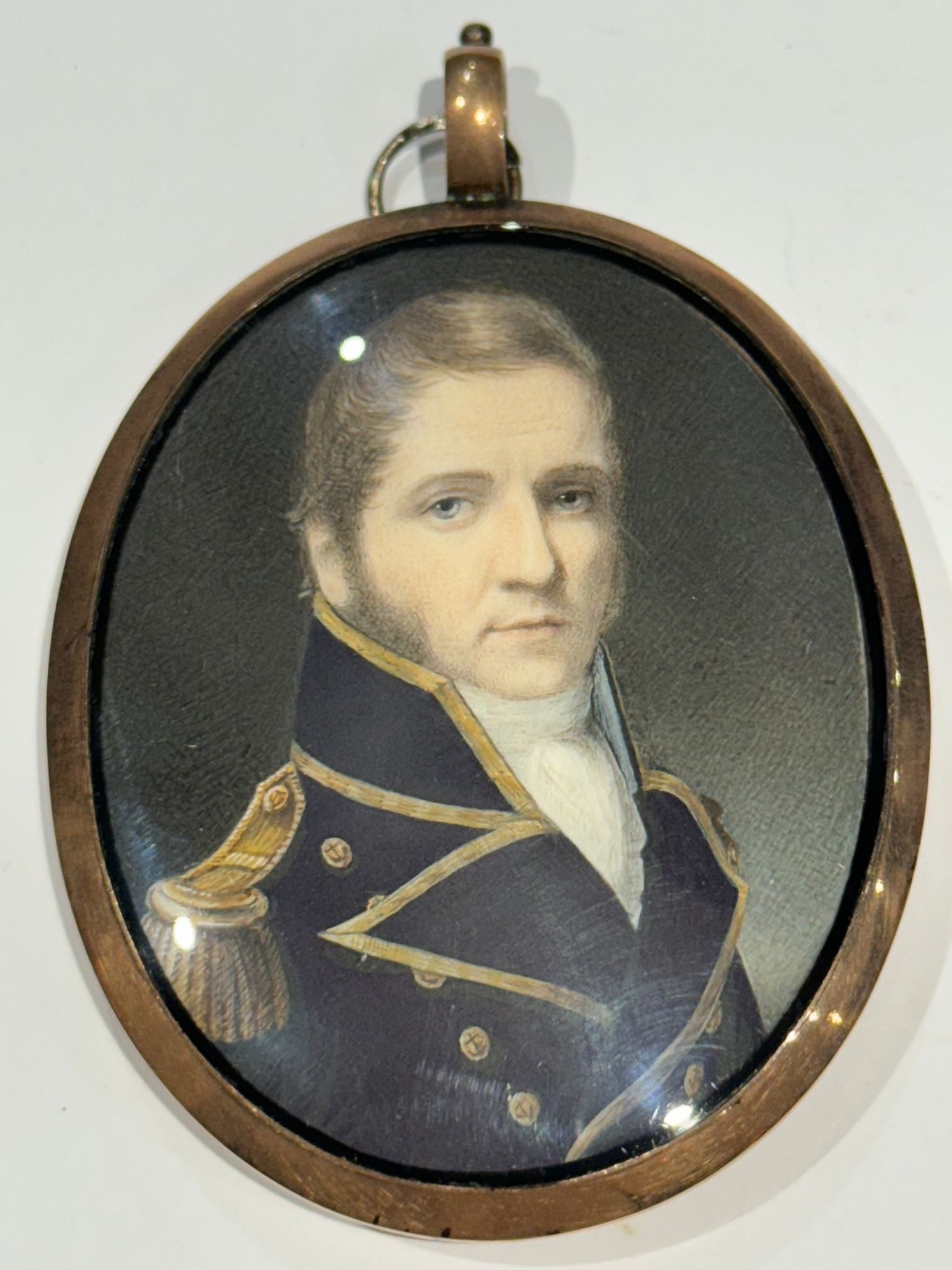 A Mid-19th century oval locket-back portrait miniature of a middle-aged senior Naval officer, with