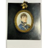 A Mid-19th century oval portrait miniature of a young Naval Lieutenant, with brown curly hair,