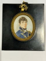 A Mid-19th century oval portrait miniature of a young Naval Lieutenant, with brown curly hair,