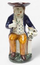 A Prattware Pottery ‘Sailor’ toby jug, c1790-1810, with blue coat and floral painted waistcoat and