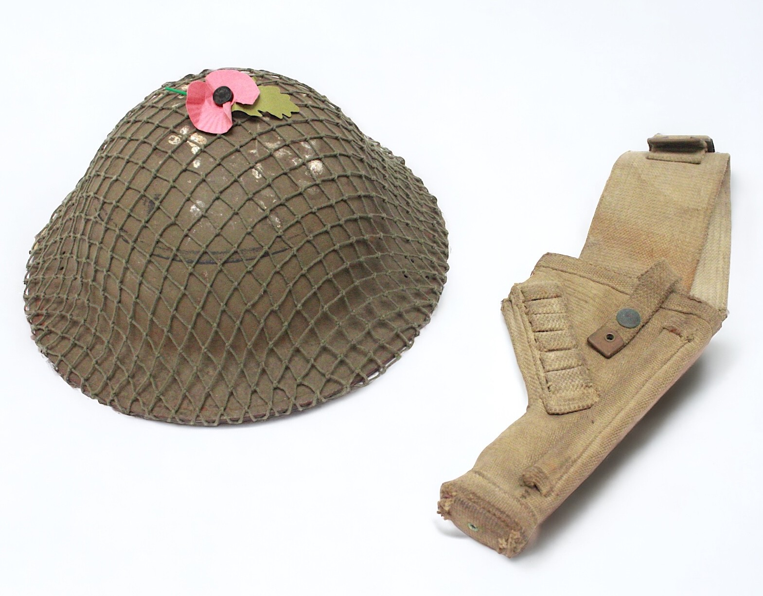 A British WWII Home Guard Brodie helmet with net cover, dated 1941, stamped ‘BMB’, together with a