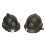 Two French WWI era steel Adrian type helmets, both with leather linings and chin straps, one with