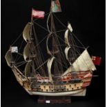 A scratch built wooden three masted model ship in full sail, with two gun decks and rigging, with