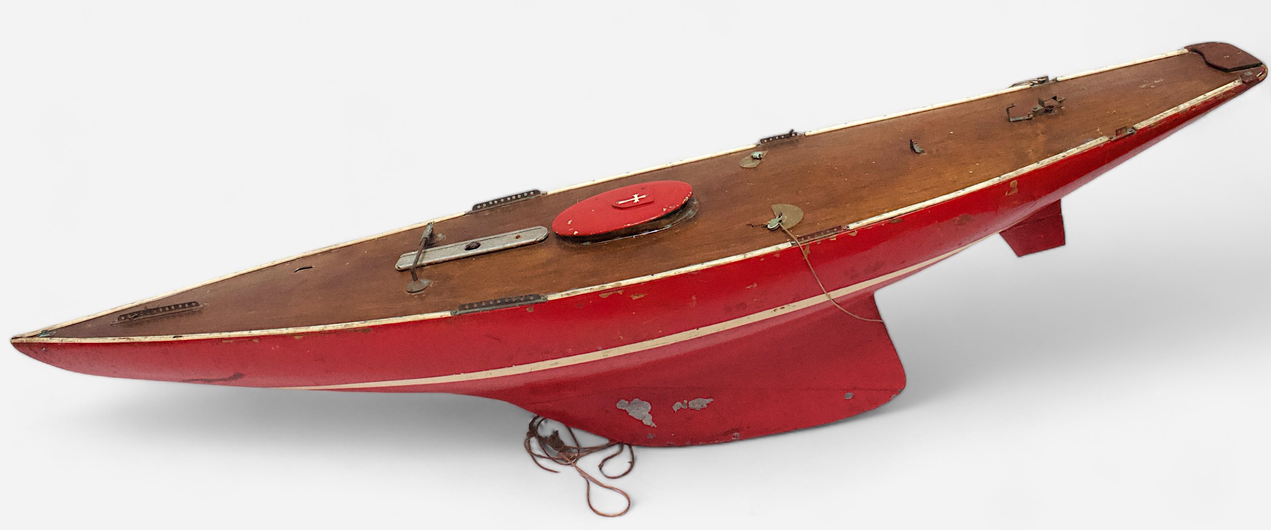 A vintage red painted Marblehead class pond yacht, with white painted stripe to hull, some parts