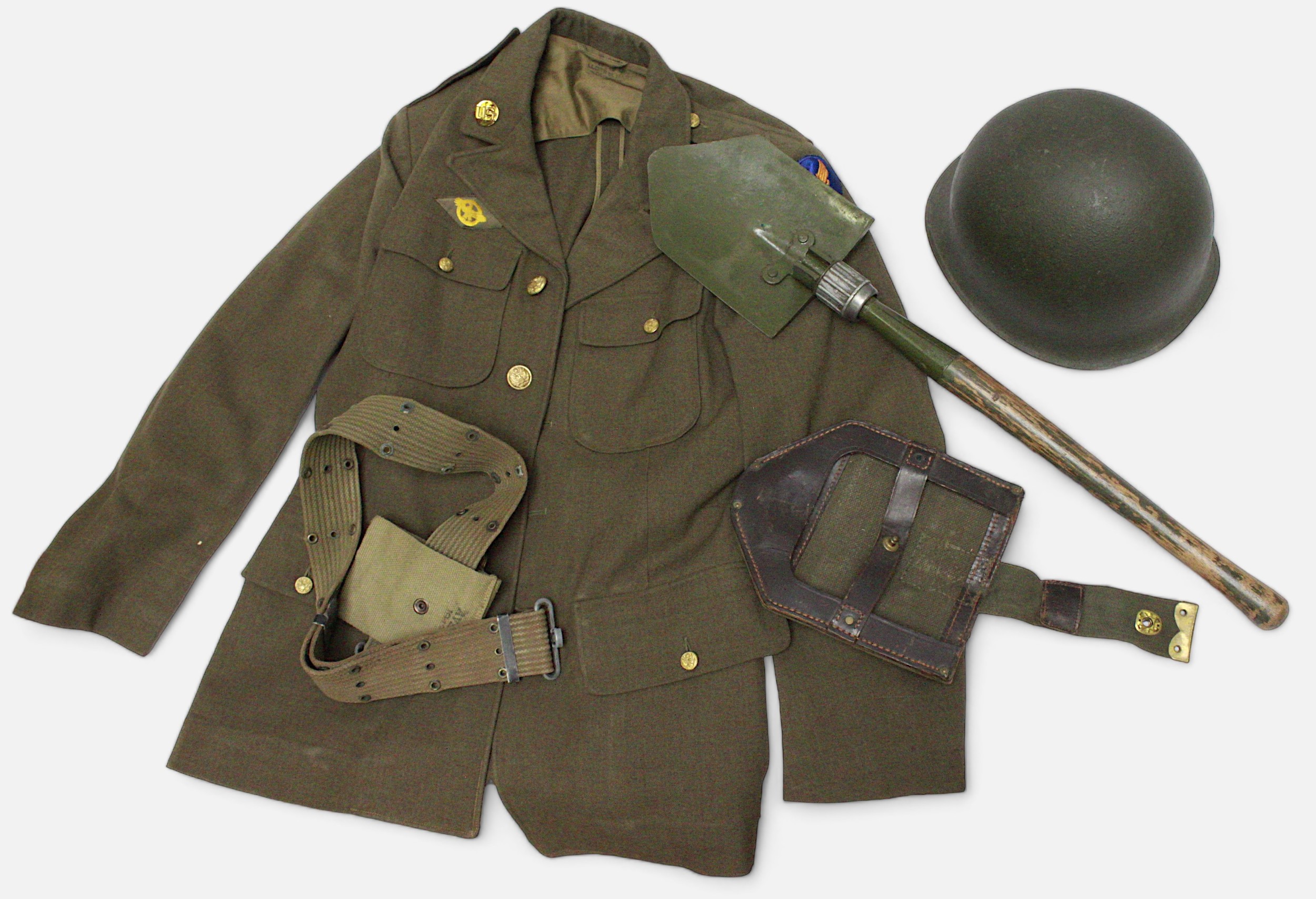 A Second World War US Army M-1943 folding entrenching tool, M1 Combat Helmet, webbing belt with