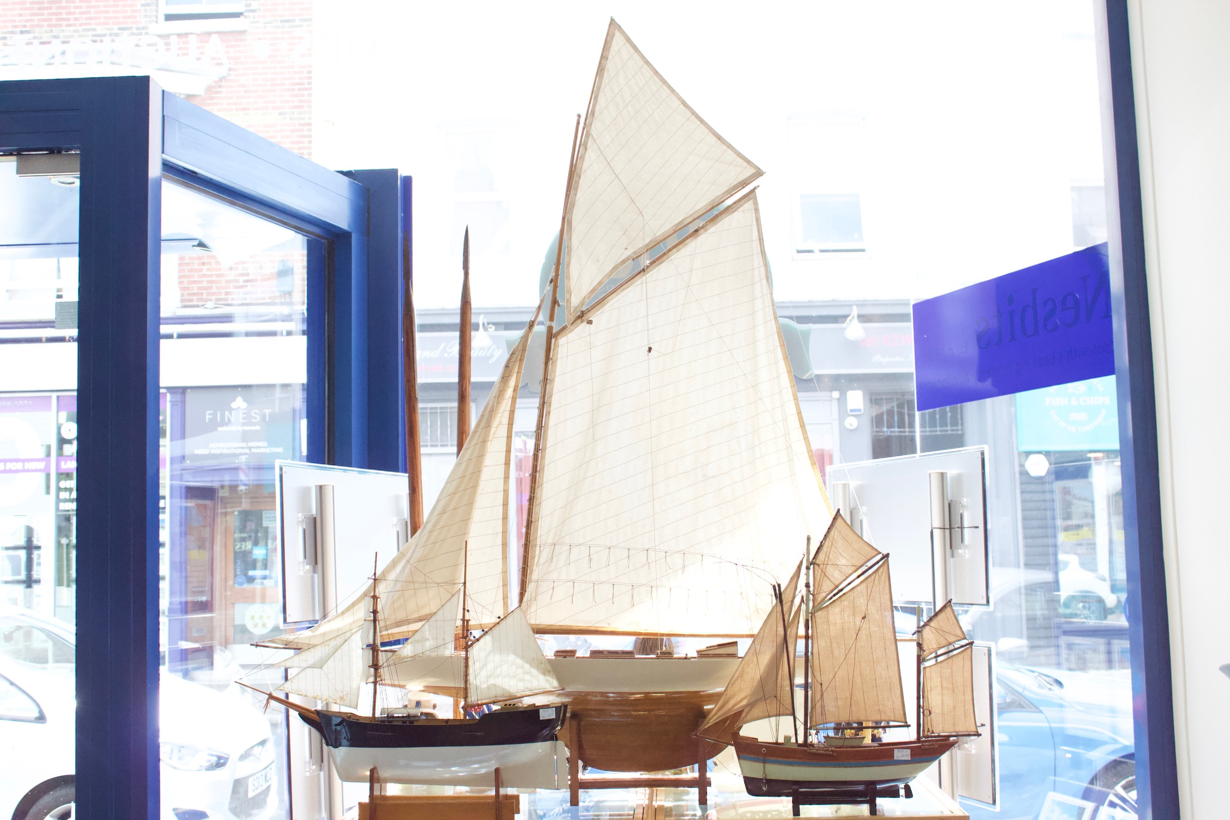 A large vintage 'Gaff-Rigged' pond yacht, with cotton sails, lined deck, cream waterline-painted