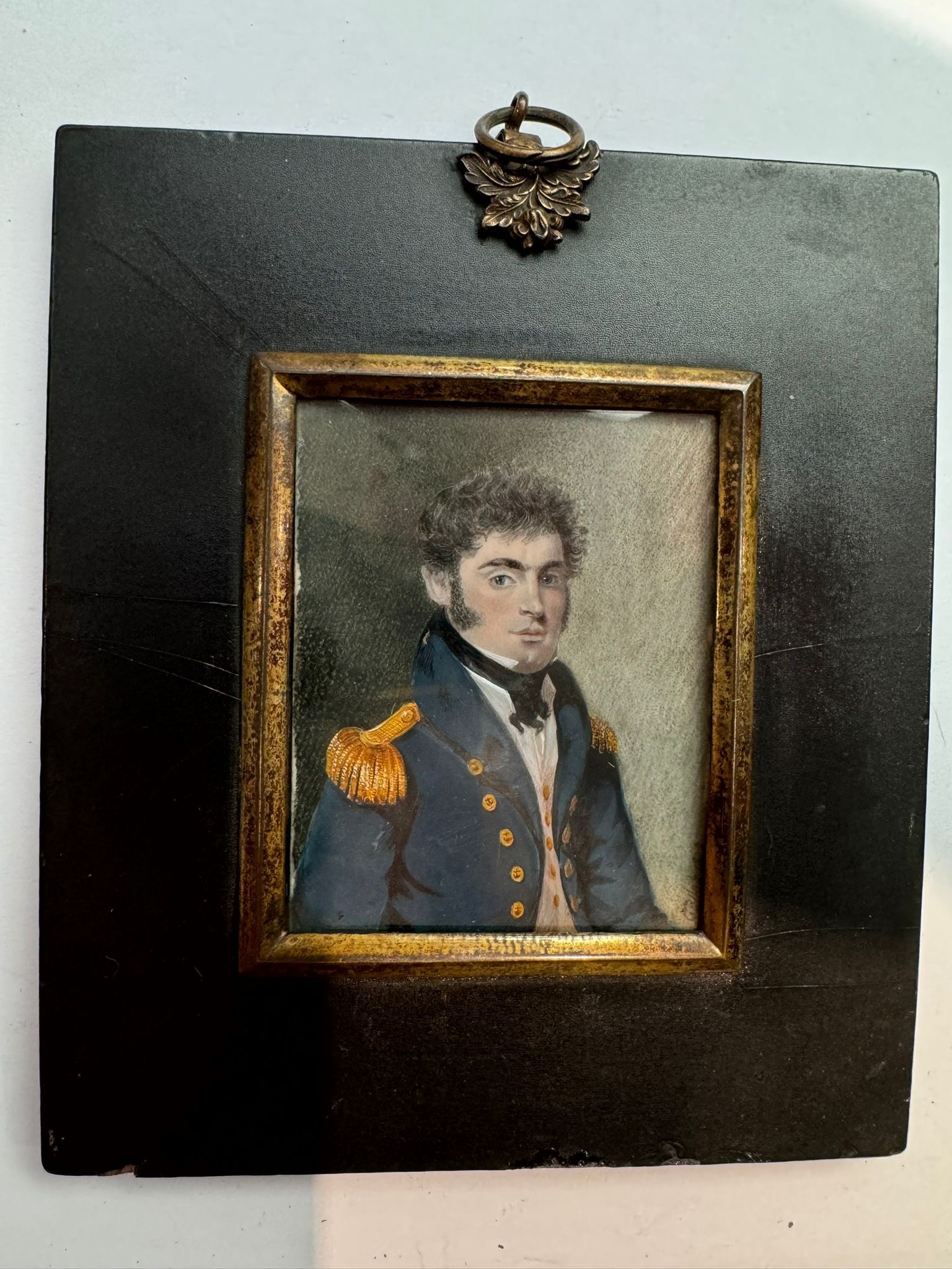 An early 19th century portrait miniature of a Senior Naval Officer, with medium length wavy black