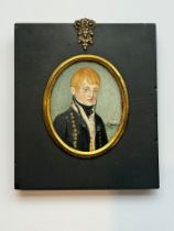 A 19th century oval portrait miniature of a young Naval Midshipman, with red hair, body turned