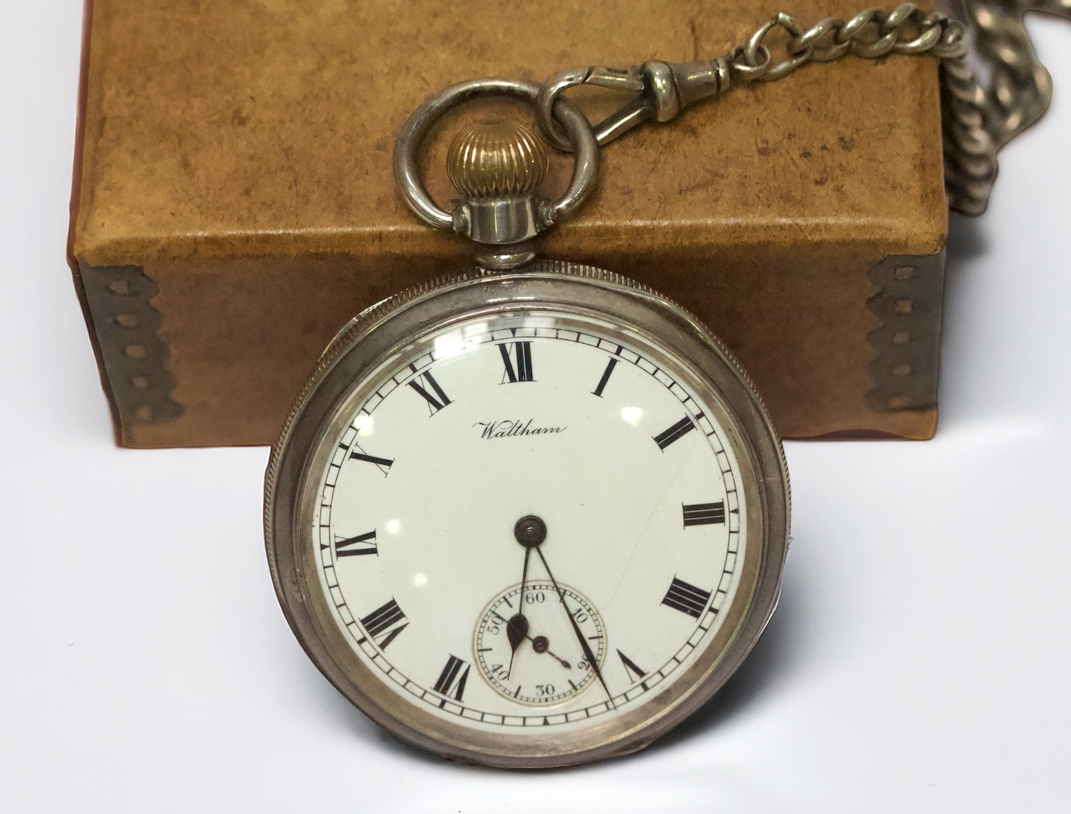 A silver-cased open face pocket watch by Waltham, the white enamel dial with Roman numerals denoting