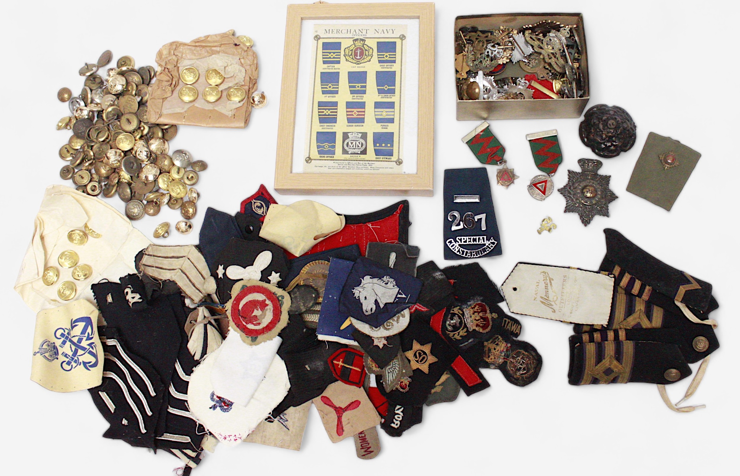 A large collection of various military cap and lapel badges, naval epaulettes, regimental buttons,