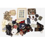 A large collection of various military cap and lapel badges, naval epaulettes, regimental buttons,