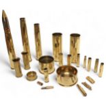 A collection of assorted brass shells including a 1953 40mm/T Mk4, a 1916 and a 1917 shell case etc.