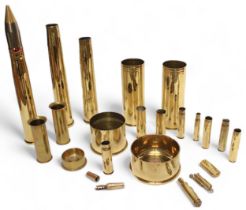 A collection of assorted brass shells including a 1953 40mm/T Mk4, a 1916 and a 1917 shell case etc.