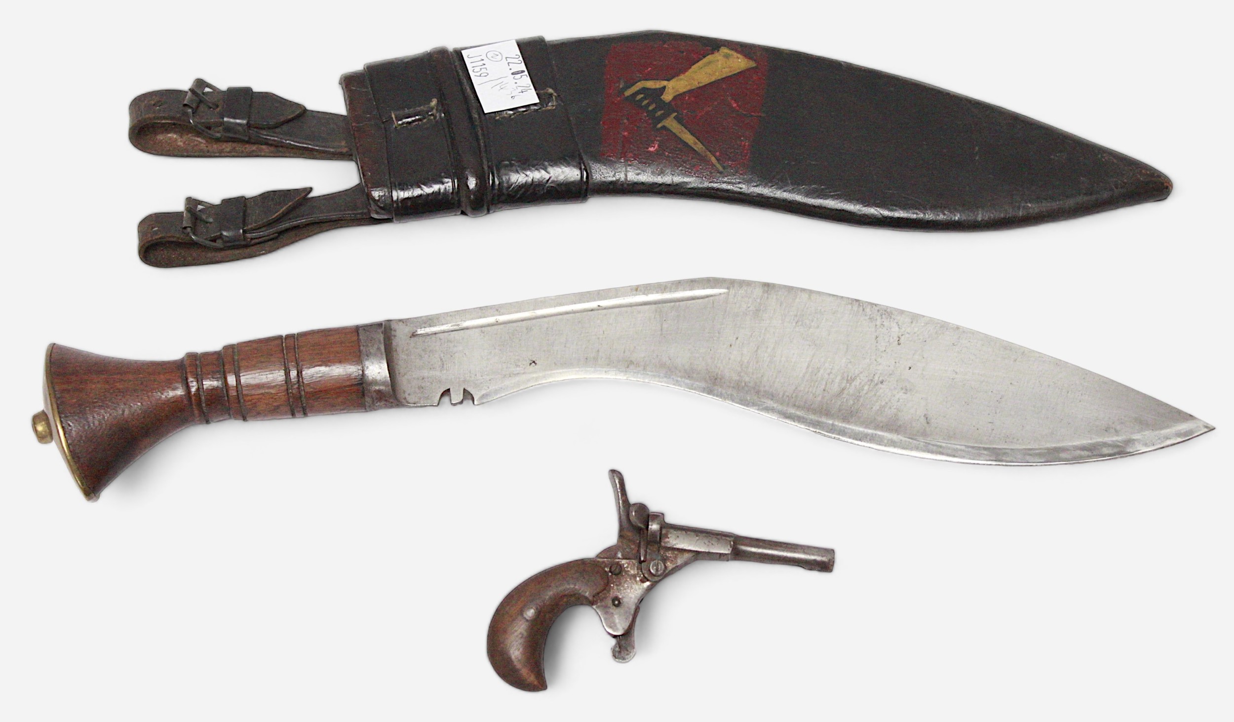 A Kukri knife with carved wooden grip and leather scabbard with illustration to side and numbered