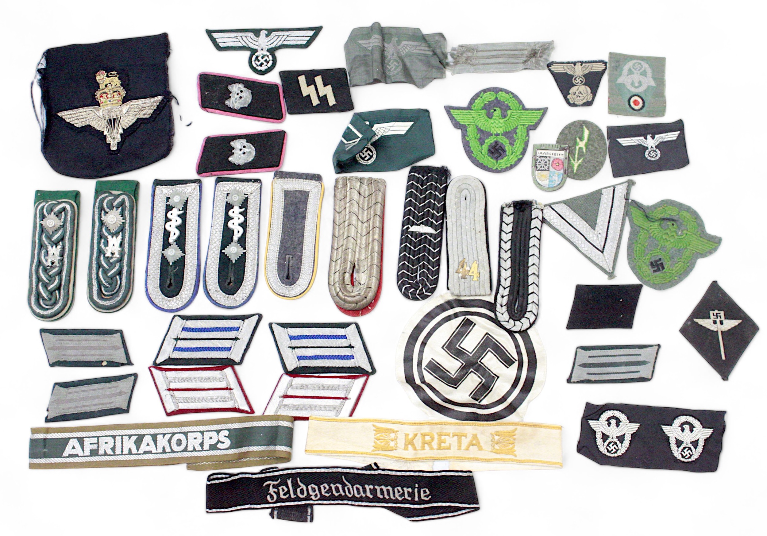 A collection of mostly German Third Reich insignia, patches, officer shoulder and collar boards,