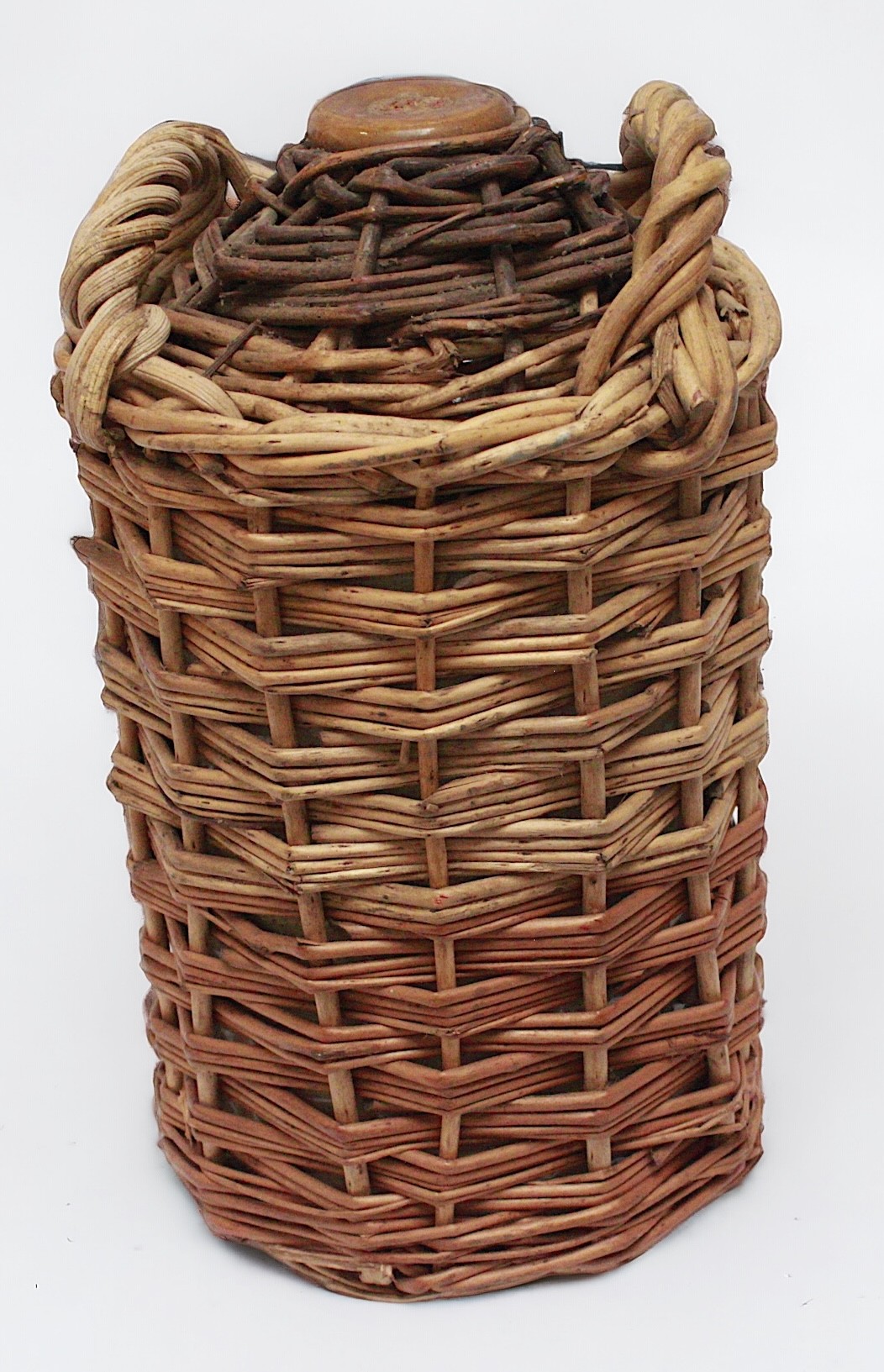 An empty Royal Navy Pusser's Rum stoneware pottery flagon in twin-handled wicker-work outer