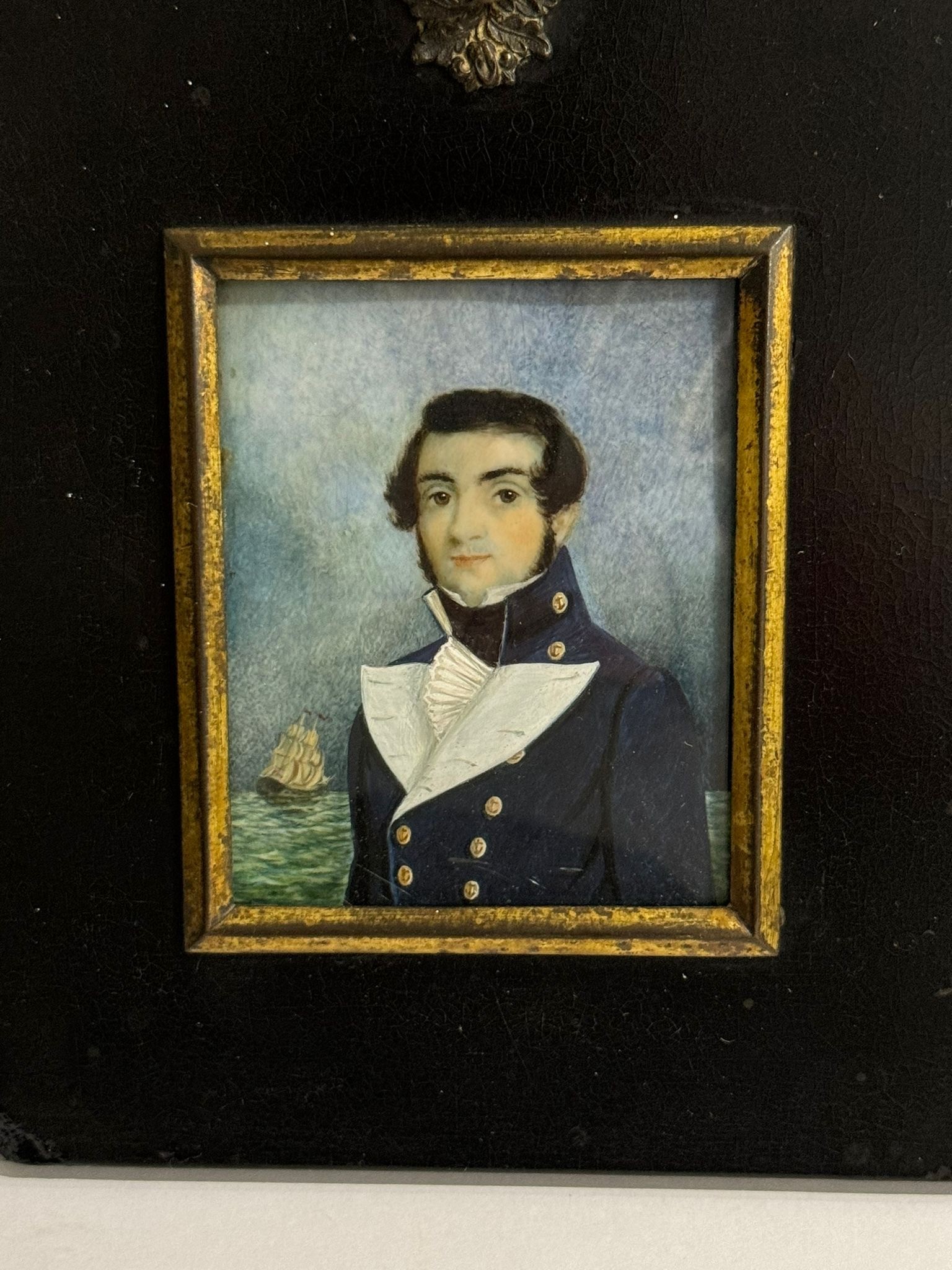 A Mid-19th century portrait miniature of a Naval Midshipman, with black wavy hair wand sides brushed