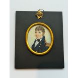 A 19th century oval portrait miniature of a naval officer, with brown hair, body turned half