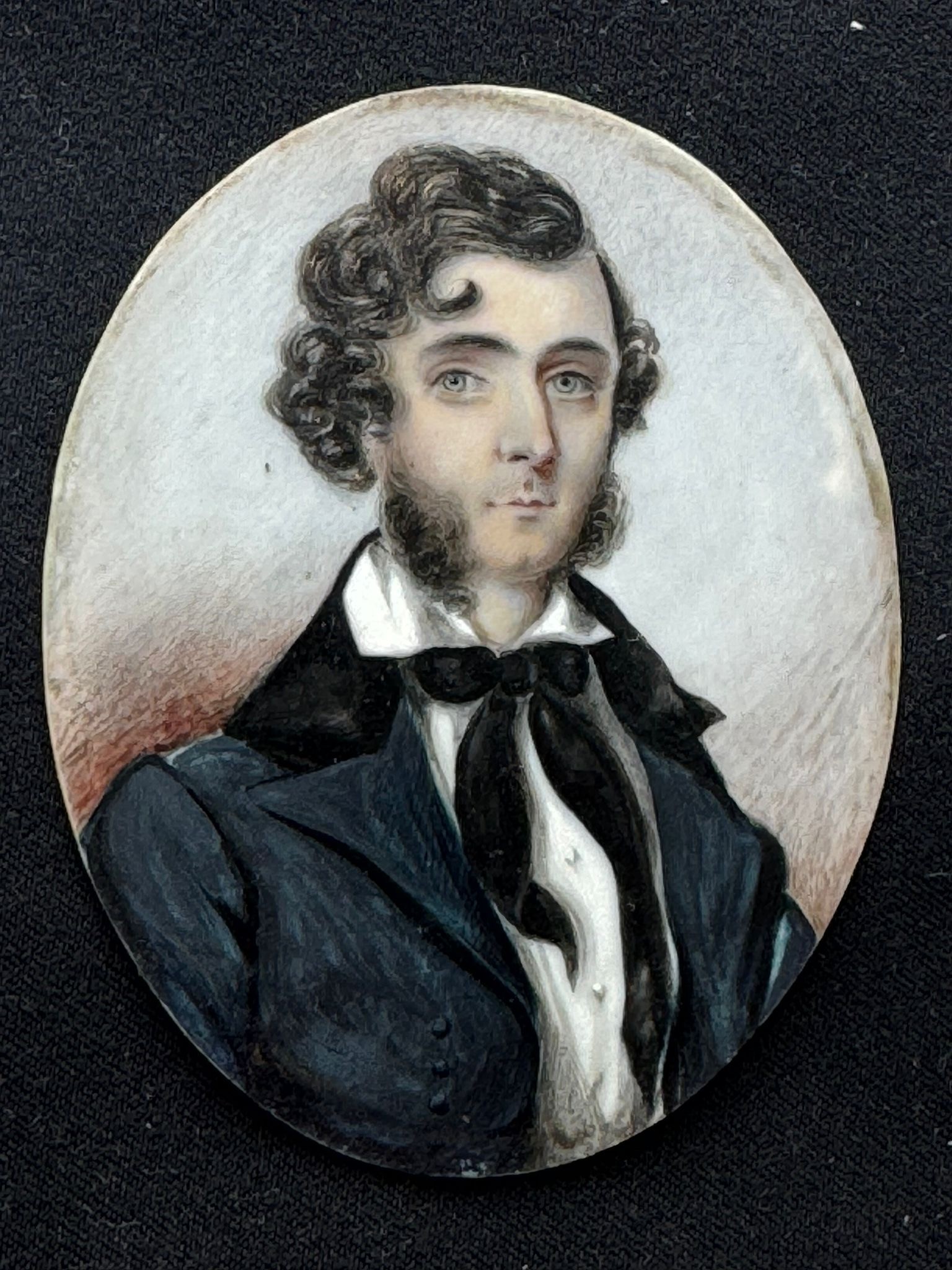 A 19th century oval portrait miniature of a young naval officer, with thick black wavy hair and ‘ - Image 2 of 2