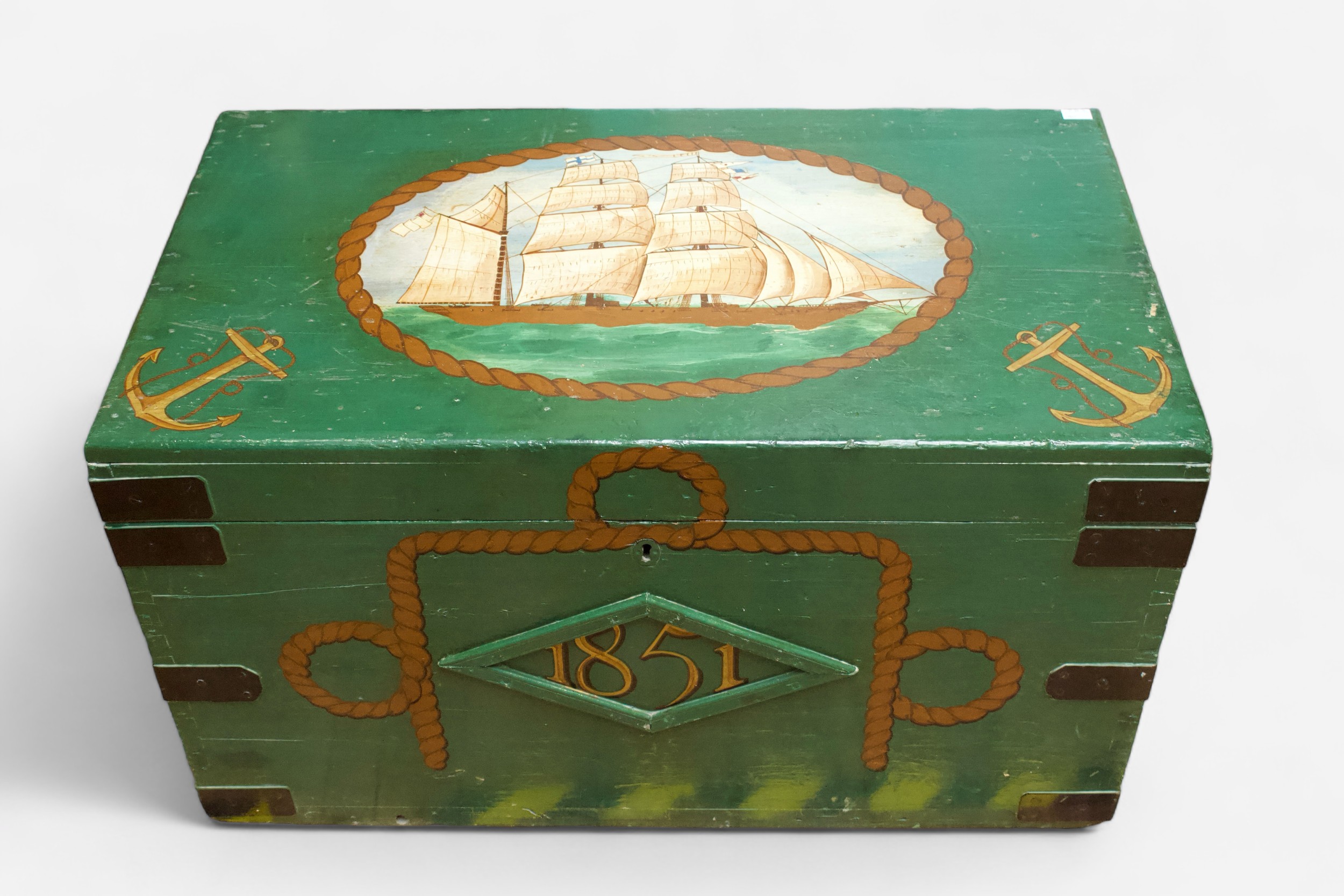 A large metal-bound wooden sea chest, later painted green and with nautical decoration to the top