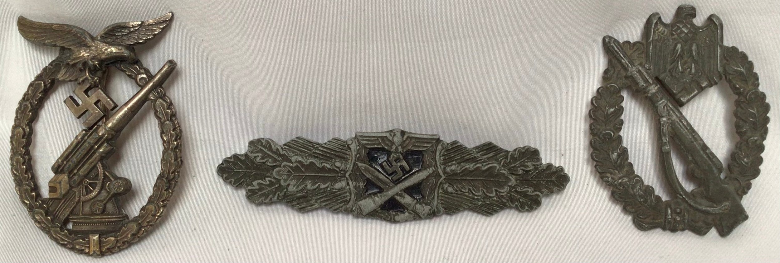 Three German WWII military badges, comprising Luftwaffe Anti-Aircraft Flak Battle Badge, Close