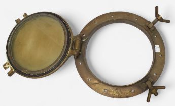 An antique brass ship’s porthole, with lockable, circular, hinged window, backplate measures 38cm