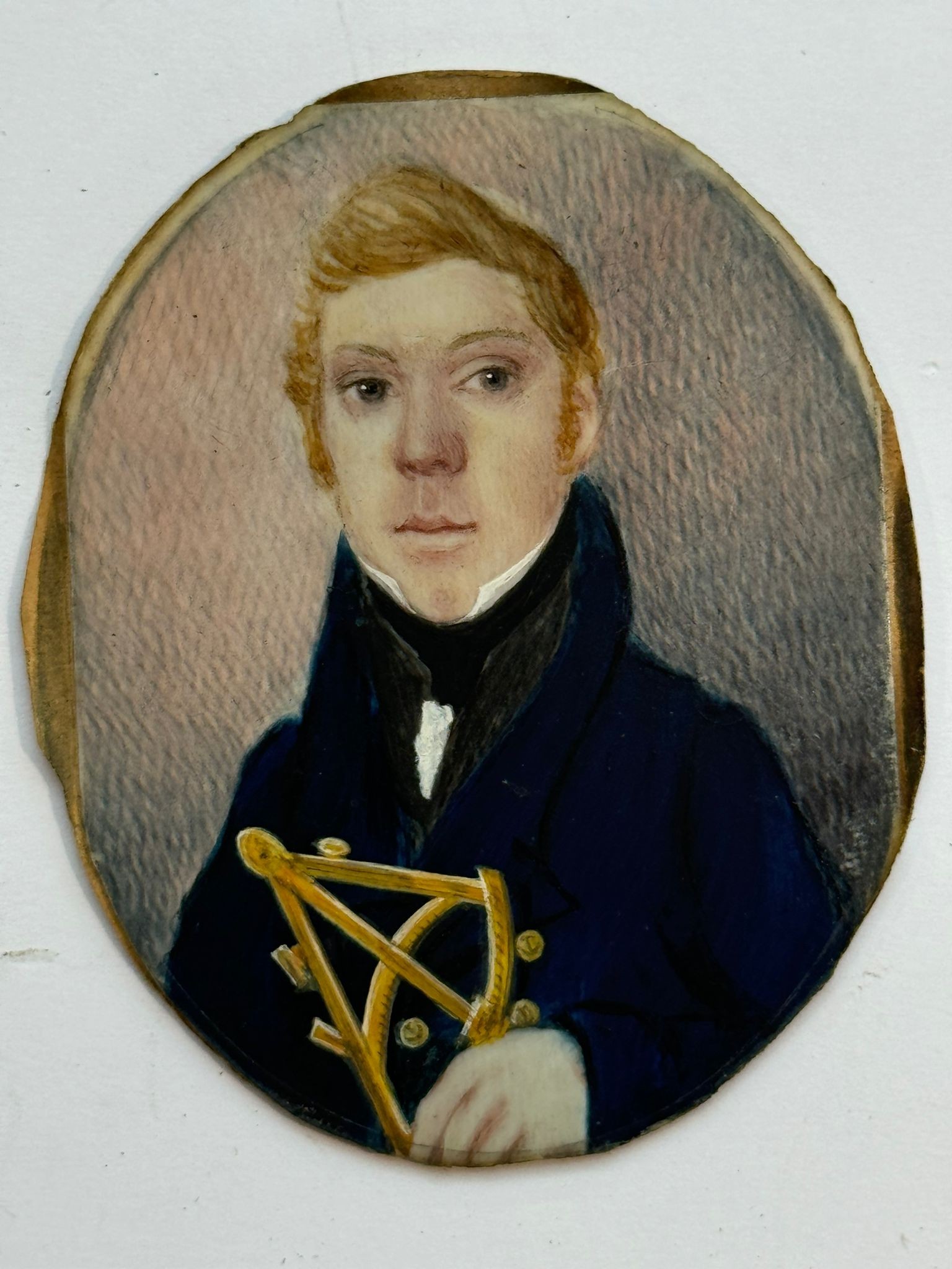 An early 19th century oval portrait miniature of a Junior Naval Officer, in right hand a brass - Image 2 of 2