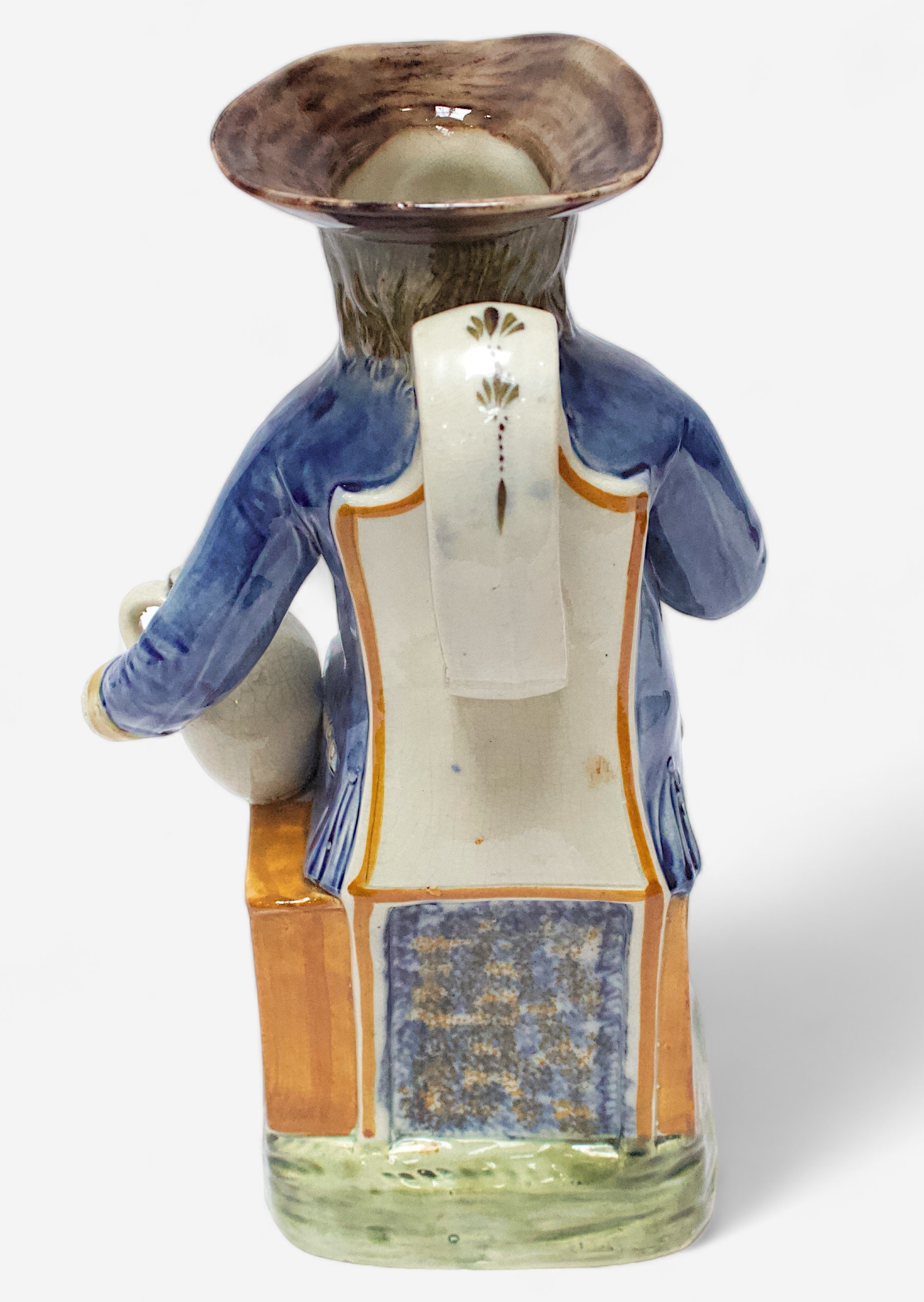 A Prattware Pottery ‘Sailor’ toby jug, c1790-1810, seated holding a jug, striped britches, blue coat - Image 3 of 4